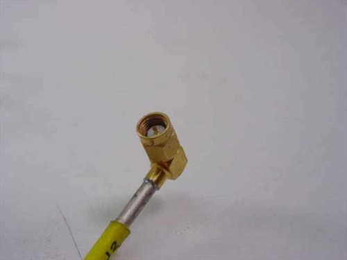 Close-up of right-angle SMA male connector end on yellow semi-rigid RF coaxial cable