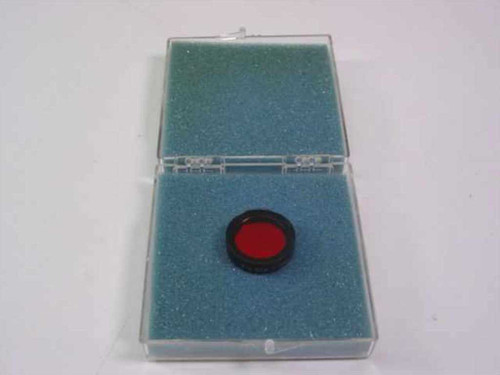 Ealing Corp 35-3961 deep red bandpass filter removed from case and sitting in open blue-foam clamshell case, red filter element visible