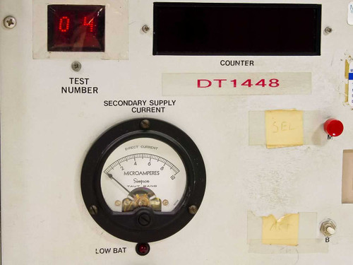 DT1448 front panel close-up showing Test Number LED display reading 04, Secondary Supply Current Simpson microammeter, Low Bat indicator, and red SEL button