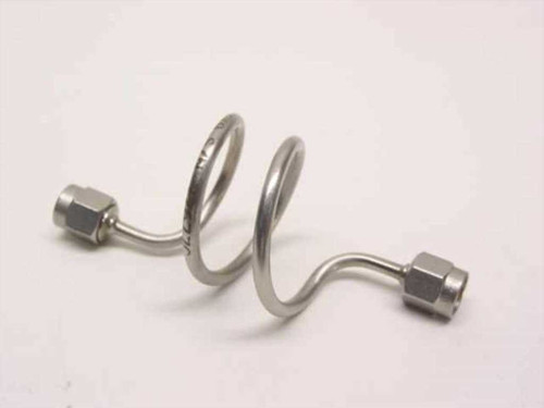 Unbranded stainless steel coiled semi-rigid SMA-M coaxial cable showing both SMA male connectors and helical coil body