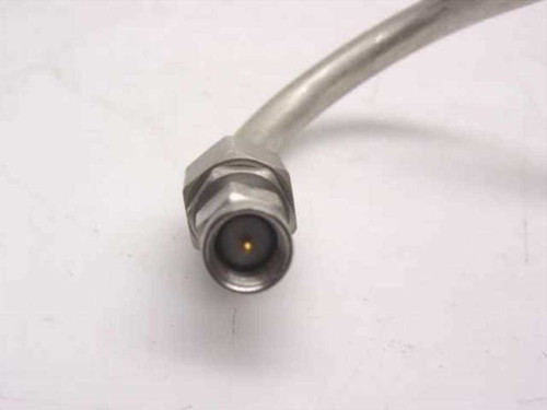 Close-up of N male connector end on semi-rigid coaxial cable assembly, showing center pin and threaded coupling nut
