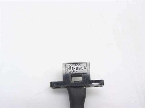 Close-up of Omron EE-SB5 sensor housing showing model number EE-SB5 and JAPAN markings with mounting flange