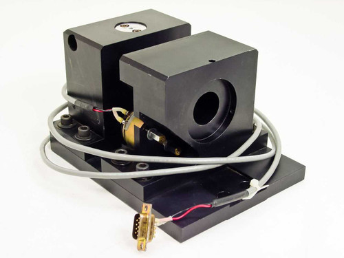 Unbranded electronic shutter assembly from mask aligner — dual black anodized housings on baseplate with rotary solenoid actuator, gray cable, and DB9 connector, three-quarter front view