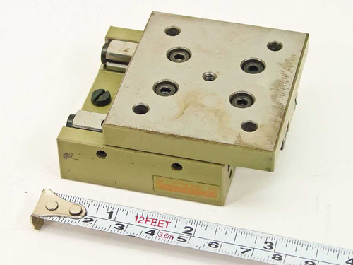 Schneeberger Rondal RF linear slide — angled top view showing tapped mounting holes and olive-green anodized body with tape measure for scale