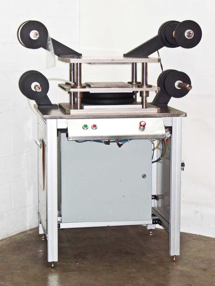 Industrial laminating press station full front view showing stainless steel platen, film roll arbors, and control panel with green and red pushbuttons