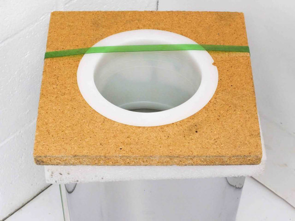 Top view of particleboard spool top showing center hub opening with green rubber band retainer securing the stainless steel roll