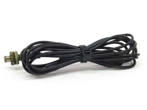 Omron E32-D11 fiber sensor cable coiled neatly with threaded barrel sensing tip visible at right