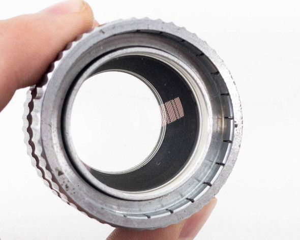 Simpson Optical Perceptordaptor 137-0001 — front face view held in hand showing internal optical element and threaded inner ring