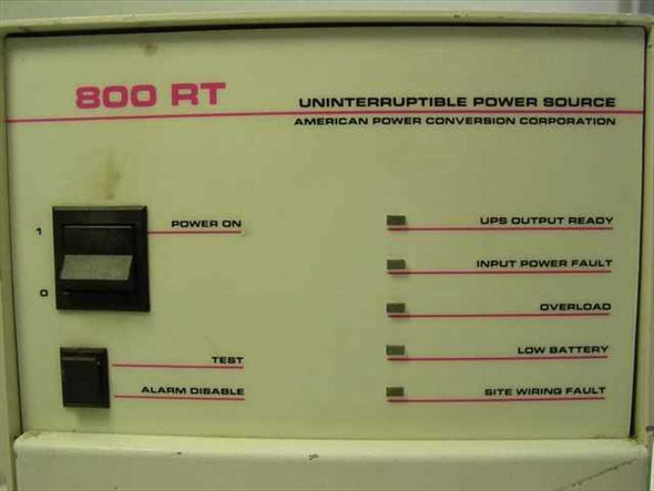APC 800RT UPS front panel close-up showing Power On switch, Test switch, Alarm Disable switch, and five LED status indicators