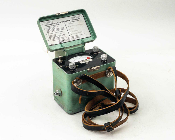 MSA Model 20 Combustible Gas Indicator — three-quarter view with lid open showing analog meter and instruction card, leather carry strap visible