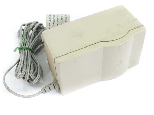 Apple M8010 StyleWriter Power Adapter — left side view showing beige housing and coiled gray DC output cable with green cable tie