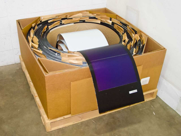 Uni-Solar PVL-128 carton of 30 flexible solar laminates coiled in large pallet shipping box, top panel showing purple amorphous cell surface