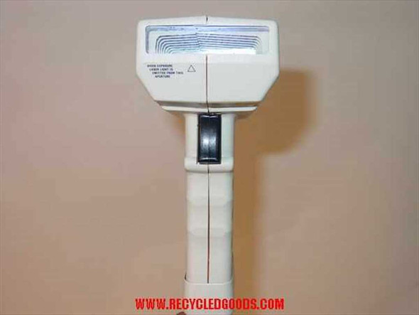Pitney Bowes J762 laser barcode scanner front aperture view showing laser warning label and trigger mechanism