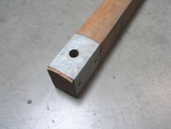 Close-up of galvanized metal end cap on U.S. Tucker military ridge tent pole showing mounting hole and square wood section
