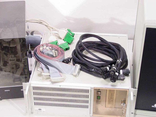 Lotus Technologies 7100 CSS tester system – close-up of rackmount computer unit with cable bundle including green DB connectors, ribbon cables, and braided power cables
