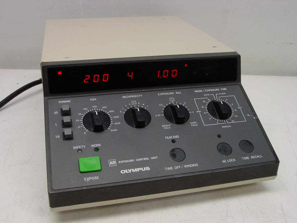 Olympus PM-CBAD AD Exposure Control Unit – front panel showing LED display reading 200 ASA, 4 frames, 1.00 exposure time with Format, ASA, Reciprocity, Exposure Adj, and Mode/Exposure Time knobs, green Expose button, Safety/Work switch, and Olympus branding