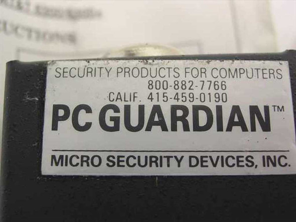 Close-up of PC Guardian label on lock body reading 'Security Products for Computers — Micro Security Devices, Inc.' with contact numbers