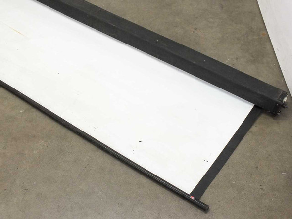 Bretford 120x72 projection screen partially unrolled on the floor, showing the white matte screen surface and black frame rails with minor surface marks
