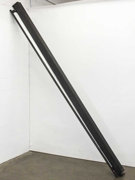 Bretford large black framed pull-down projection screen leaning vertically against a wall, showing full length of the black aluminum frame and roller housing