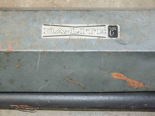 Da-Lite Model C label close-up on steel housing showing brand logo and rust spots on case exterior