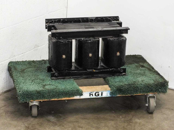 11062A 9kVA three-phase transformer front view showing three black coil cores on steel frame, sitting on green carpeted dolly