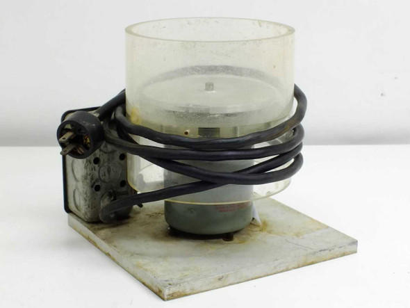 Unbranded spin coater spinner rear/side view showing motor housing, power cord, and clear cylindrical bowl on base plate