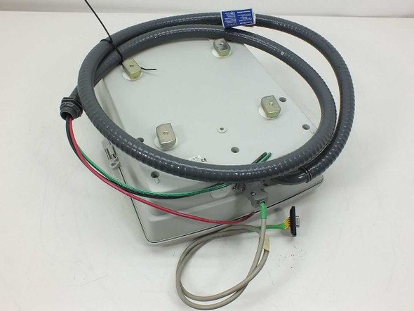 Bottom view of ADAM-4011 electrical enclosure showing four mounting feet, wiring conduit loop, and external cable with DB-9 connector