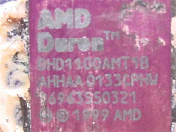 AMD Duron DHD1100AMT1B processor die label — close-up showing model number DHD1100AMT1B, stepping AHHAA0133CPKW, and 1999 AMD copyright