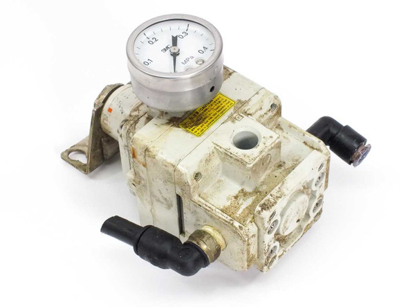 SMC IR3010-02BG pneumatic pressure regulator front-left view showing integral gauge and black push-in fittings with heavy surface wear and grime