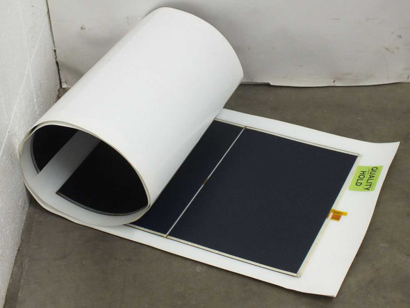 Xunlight XLS8-52 flexible amorphous solar panel partially rolled up showing ETFE top sheet and dark cell surface with Quality Hold label visible