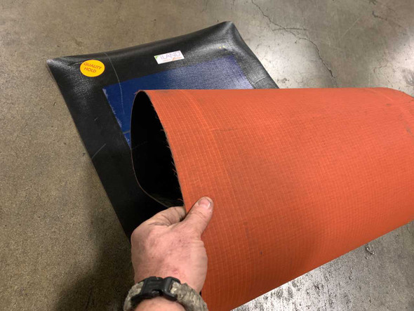 Xunlight XSS11-35 flexible solar panel being rolled or bent, showing flexible backing and orange underside