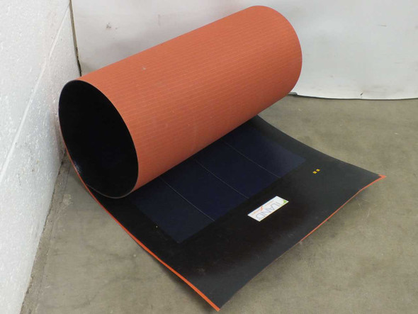 iLand XZS8-16 flexible amorphous solar panel partially unrolled showing dark blue amorphous cell side and orange textured backing, with manufacturer label visible near solder points