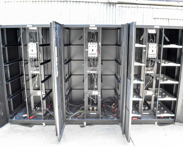 Three Eaton 9395 battery cabinets with doors open showing empty battery trays, interior wiring, and HKD-DC breakers