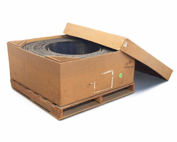 Uni-Solar PVL-128 128W flexible solar laminate roll inside open carton on pallet, top-down angle showing layered dark laminate material