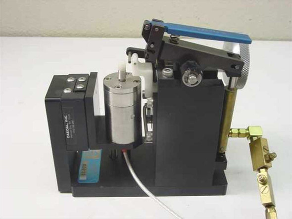 Daedal pneumatic clamp assembly right side view showing Daedal Inc label on black module, blue lever, pneumatic cylinder, and brass fittings