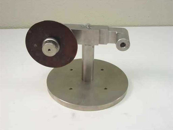Custom Scientific stainless steel component holder stand — front-right view showing round bolt-down base, vertical post, adjustable pivot arm, and dark abrasive or rubber disc mounted on center hub