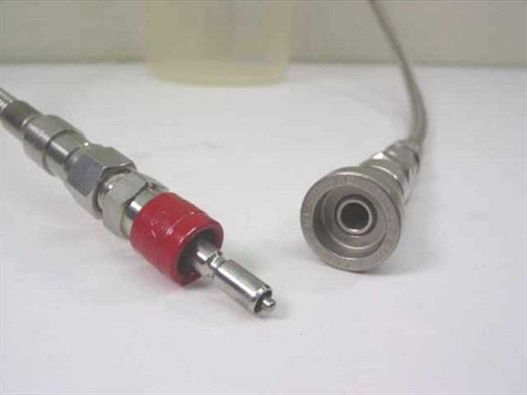 Close-up of stainless steel braided hose connectors — left hose shows red-collared quick-disconnect fitting, right shows SS female quick-disconnect end