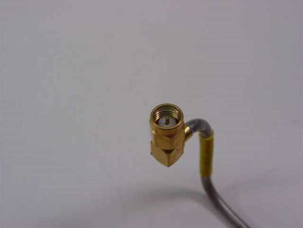Close-up of gold-plated SMA male right-angle connector on semi-rigid coaxial RF cable with yellow sleeve