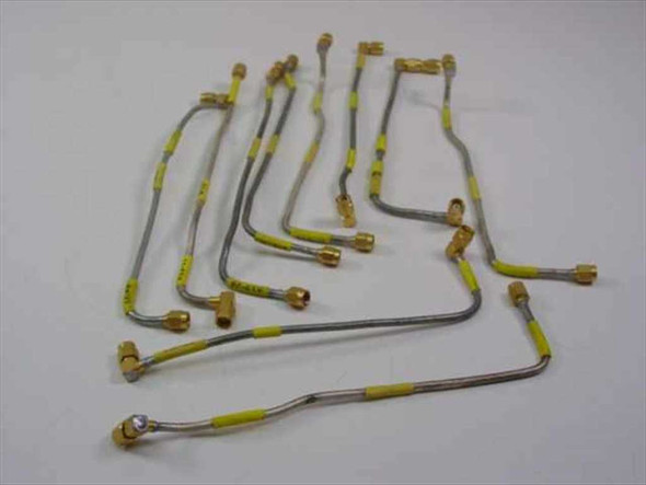 Lot of 10 flexible SMA male right-angle RF coaxial cables with yellow jacket and gold-plated connectors spread out on a surface