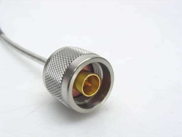 Close-up of N-male connector end showing knurled stainless steel coupling nut and gold-plated center pin on semi-rigid 0.141 coax cable