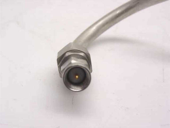 Close-up of N male connector end on semi-rigid coaxial cable assembly, showing center pin and threaded coupling nut