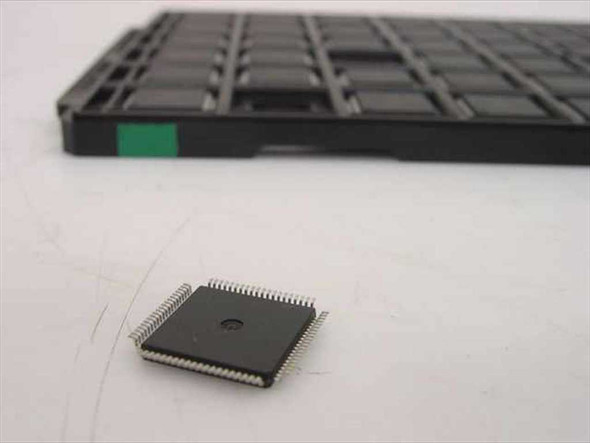 Motorola DSPE56009FJ81 DSP chip beside factory LQFP IC tray showing chip size and package