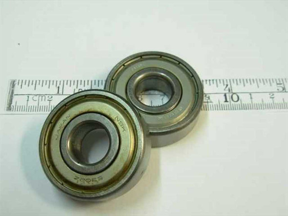 NSK 6204-2Z double shielded steel ball bearings shown next to a ruler — two bearings, top and angled views showing shield faces and bore