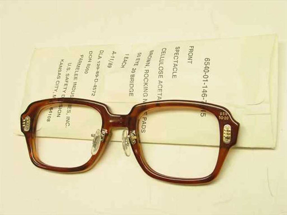 USS 6540-01-146-7815 military spectacle frame three-quarter view showing adjustable rocking nose pads and 50/20 size markings on label