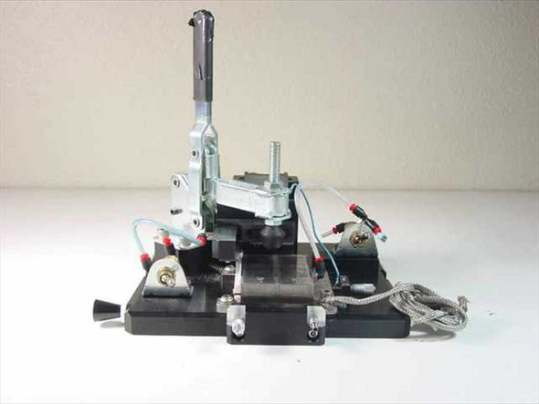 Custom vacuum chuck assembly front-left view showing toggle clamp arm, pneumatic tubing, linear bearing, and aluminum base plate