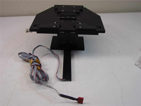 6-Position Logic Driven Pedestal Cassette Tray front-angle view showing black aluminum tray platform on steel pedestal with ribbon cable harness and red Molex connector