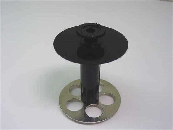 Epson ABS label printer media spool — top view showing black ABS plastic upper disc with toothed gear hub and metal base flange with four oval cutouts