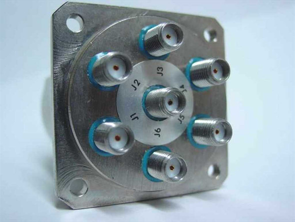 K&L Microwave 6MP-28-F-0-4 SP6T coaxial relay — bottom flange view showing six SMA female connectors labeled J1 through J6 arranged radially with blue seals on stainless mounting plate