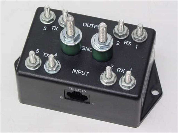 Northern Technologies TCS-T1DS top view showing OUTPUT and INPUT screw terminals, TX and RX lugs, GND posts, and TELCO RJ port