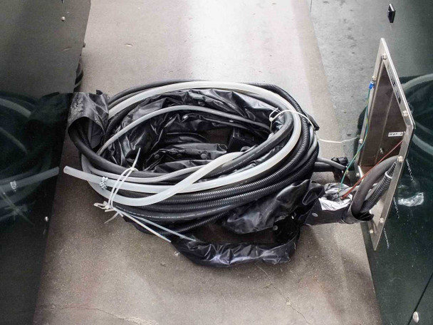 Yamashita Denso PXS-0855MP — loose cable bundle including corrugated conduit hose, flat ribbon cables, and signal wires with stainless steel junction panel visible on cabinet side